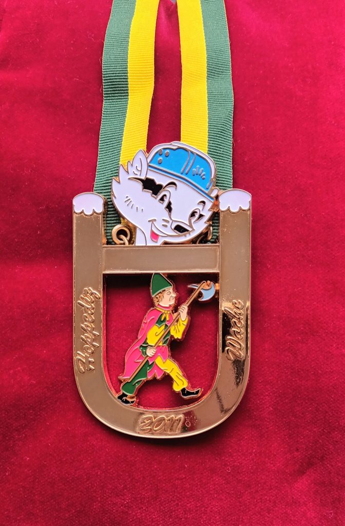 Orden 2010-2011 - Der Hoppediz-Wächter mit dem U-Bahn-Dachs zum Sessionsmotto Jebuddelt, jebaggert, jebützt Orden 2010-2011 - Der Hoppediz-Wächter mit dem U-Bahn-Dachs zum Sessionsmotto Jebuddelt, jebaggert, jebützt